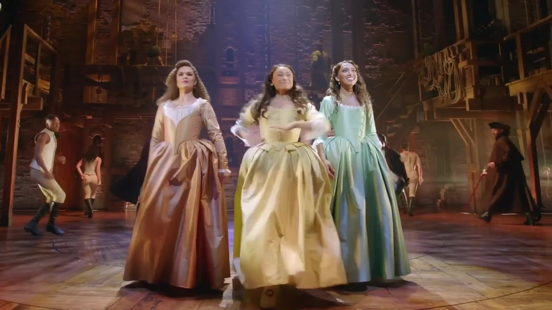 The Hamilton company mid-number in period costume on the arena stage